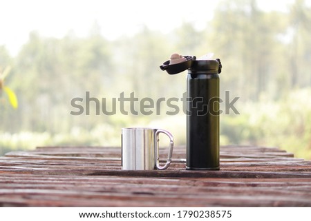 a tumbler mug and a cup in the wooden table