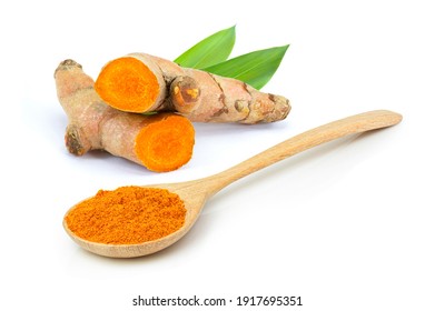 Tumeric rhizome with green leaf and turmeric powder in wooden spoon isolated on white background.