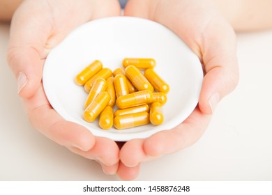 Tumeric Supplements With Female Hands 