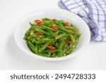 Tumis buncis or stir fry french bean or string beans served in white plate. Selective focus.