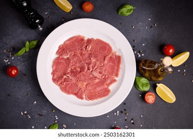 tuna carpaccio - slices of fresh raw tuna fillet on white ceramic plate - Powered by Shutterstock