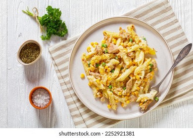 Tuna Mornay, Creamy Tuna Casserole Penne Pasta Bake on plate with fork on white wooden table, flat lay