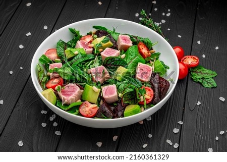 Tuna salad. Japanese traditional salad with pieces of medium-rare grilled Ahi tuna and sesame with fresh vegetable on a bowl. Authentic Japanese food. Top view