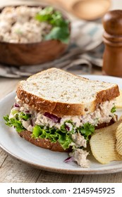 Tuna Salad And Lettuce Sandwich On Whole Grain Bread With Potato Chips On A Plate