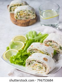 Tuna salad roll sandwich with salad leaves on white plate. Roll sandwich with tuna, cucumber, eggs and dill. Thin Armenian pita bread or lavash. Snack.