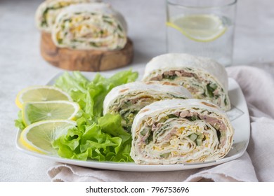 Tuna salad roll sandwich with salad leaves on white plate. Roll sandwich with tuna, cucumber, eggs and dill. Thin Armenian pita bread or lavash. Snack.