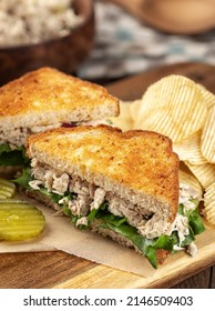 Tuna Salad Sandwich With Lettuce On Toasted Whole Grain Bread Cut In Half On A Cutting Board