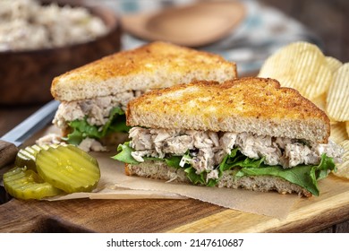 Tuna Salad Sandwich With Lettuce On Toasted Whole Grain Bread Cut In Half On A Cutting Board