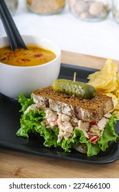 Tuna Salad Sandwich With Lettuce On Rye Toast With Butternut Squash Soup, Potato Chips, And A Pickle