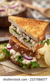 Tuna Salad Sandwich With Lettuce And Red Onion On Toasted Whole Wheat Bread Cut In Half And Stacked