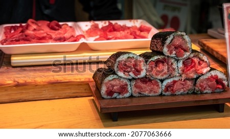 A tuna sushi take-out stall in Tsukiji Market. Man preparing goods in seafood at restaurant in Tokyo. Famous marketplace. Delicious japanese food.