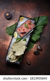 Tuna Tartare Served On Ice With Red Caviar, Micro Greens And Lemon Slices. Overhead View, Flat Lay