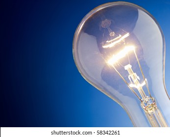 Tungsten Lightbulb On Blue Background. Horizontal Shape, Copy Space