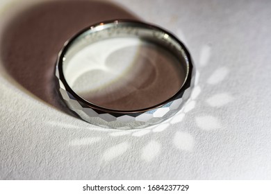 Tungsten Ring Lying With Light Reflection.