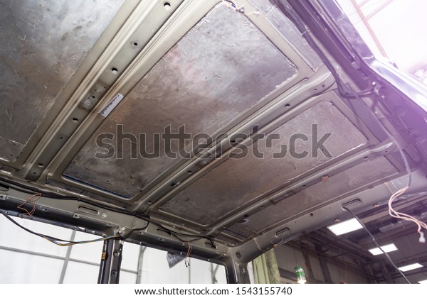 Tuning the car in a van bus body with three\
layers of noise insulation on the metal roof. Sound and vibration\
isolation using soft and rubber material with a car breakdown. Auto\
service undustry.