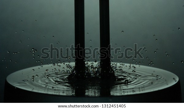 Tuning Fork in Water vibrating musical note\
with droplets\
reverberating