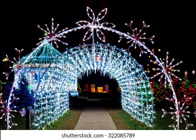 A Tunnel Of Christmas Lights Adds A Bright Note To A Festive Village Outdoor Display