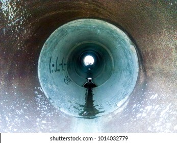 Tunnel for draining rainwater under the road. View through the pipe.