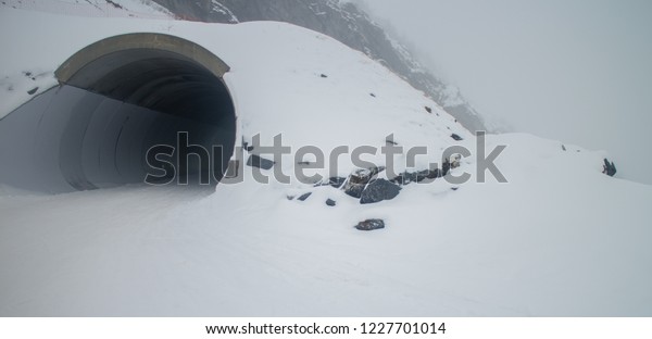 Tunnel Through The Snow In French\
Ski Resort, Earie Darkness in Tunnel with background\
mist
