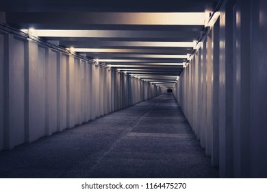 tunnel, underground pedestrian crossing at night. A long concrete tunnel with lanterns in the city underground. Underpass. - Powered by Shutterstock