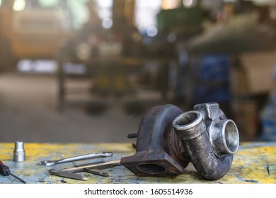 Turbocharger and repair tools on the working table, mechanical maintenance and repair  background