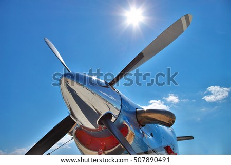 Turboprop plane engine and propeller closeup view against the sun in the blue sky