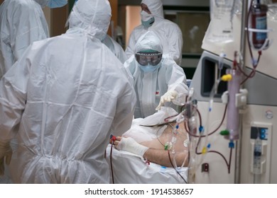 TURIN, ITALY - APRIL 21, 2020:  A Doctor In Full PPE Work On A Patient In Intensive Care In The COVID-19 Ward Of The Maria Pia Hospital In Turin.