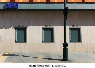 Turin, Italy. Cinema Sign On A Facade And Three Empty Green Billboard Showcase For Movie Poster Or Show Advertising Along The Sidewalk. Copy Space Available.