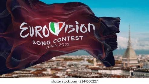 Turin, Italy, January 2022: The flag of the Eurovision Song Contest 2022 logo waving in the wind with blurred landscape of Turin city. The 2022 edition will take place in Italy from 10 to 14 May