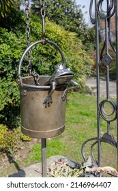 Turin, Italy - March 19, 2022: Detail of a well with an iron frog in the bucket.