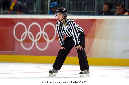 TURIN, ITALY-FEBRUARY 13, 2006: Female Ice Hockey referee with the Olympic rings on the background, at the Winter Olympic Games of Turin 2006.