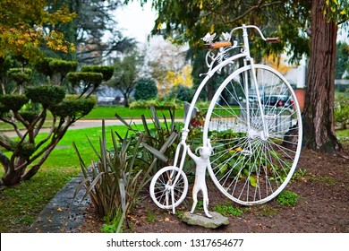 Turin, Piedmont, Italy - October 29 2019: A Small White Cat Tries To Get On The Saddle Too High Of An Old Bike , In The Center Of Turin, Piedmont, Italy