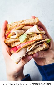 Turkey And Apple Sandwich In Hands, Top View. Thanksgiving Leftovers Concept.