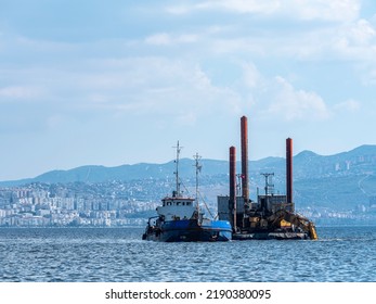 Karşıka, İzmir Turkey,
August 2022
Garbage Collection At Sea, Large Construction Machine Empties The Garbage At The Bottom To Another Garbage Collection Ship