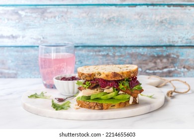 A Turkey And Bacon Club Sandwich Served With A Pink Grapefruit Spritzer.