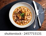 Turkey, beans, and sun-dried tomatoes stew - a hearty protein-rich dish. Traditional rural kitchen concept. A manually taken photo, not AI