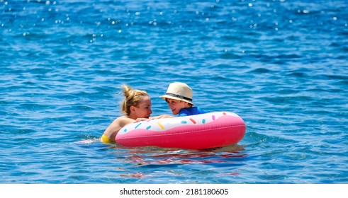 Turkey Bodrum 19 June 2021. Happy Young Woman With Son On Inflatable Ring In The Blue Sea. 