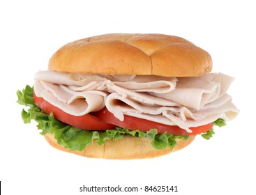 Turkey Breast Sandwich With Lettuce And Sliced Tomato On A Bun Isolated On White