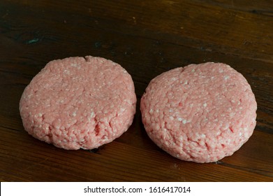 Turkey Burger Patties. Raw Ground Turkey Formed Into Hamburger Patties. Grade A Turkey Ground In A Meat Grinder Mixed W/ Seasonings & Spices & Garlic & Shot On Wooden Block. Sold At Butcher Shops.