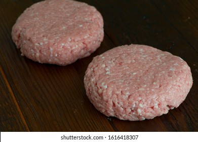 Turkey Burger Patties. Raw Ground Turkey Formed Into Hamburger Patties. Grade A Turkey Ground In A Meat Grinder Mixed W/ Seasonings & Spices & Garlic & Shot On Wooden Block. Sold At Butcher Shops.