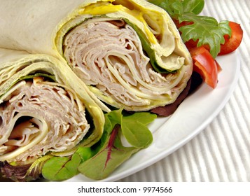 Turkey, Cheese, And Lettuce Wrap Sandwich With Carrots And Peppers.