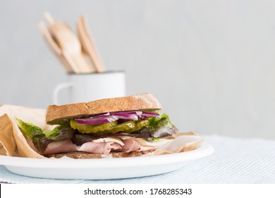turkey deli sandwich on a plate with vegetables front view, sustainable tableware concept