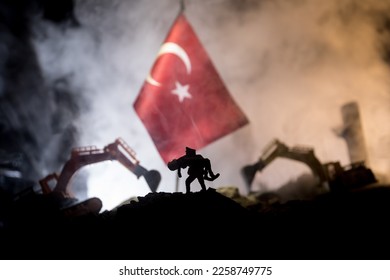 Turkey Earthquake happend in February 2023. Decorative photo with Turkish flag, and ruined city buildings. Pray for Turkey. Selective focus