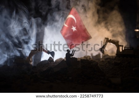 Turkey Earthquake happend in February 2023. Decorative photo with Turkish flag, and ruined city buildings. Pray for Turkey. Selective focus