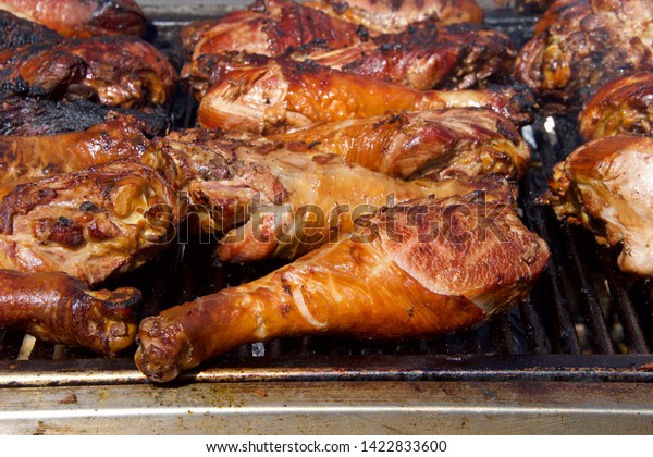 Turkey legs grilling on a\
BBQ grill. Giant turkey legs are a very popular food for street\
fair vendors.