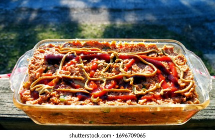 Turkey Meat Loaf With Mustard And Bar B Que BBQ Sauce Drizzled Across Top, In A Small Glass Bread Pan.