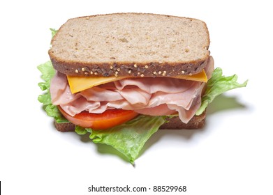 Turkey Sandwich With Lettuce, Tomato And Cheese On Whole Grain Wheat Bread Isolated On A White Background