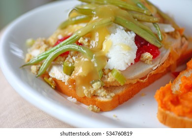 Turkey Sandwich Made From Thanksgiving Dinner Leftovers Including Mashed Potatoes, Turkey, Cranberry Sauce, Stuffing, Green Beans And Sweet Potatoes