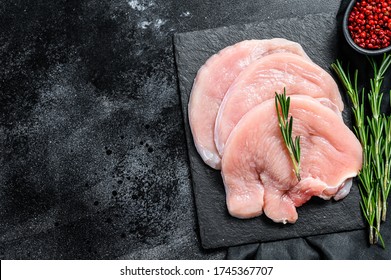 Turkey Steaks With Rosemary And Pink Pepper. Raw Organic Poultry Meat. Black Background. Top View. Copy Space