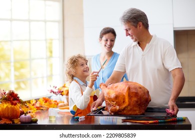 Turkey For Thanksgiving. Family Cooking Festive Dinner. Mother, Father And Child Roast Meat In Decorated Kitchen. Mom, Dad And Kid Cook For Autumn Holiday Meal. Fall Season Food And Home Decoration